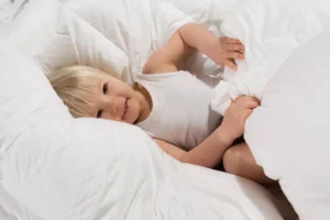 Dieťatko oddychuje v jemnej páperovej perine Atelliere – prírodné periny pre zdravý a pokojný spánok.